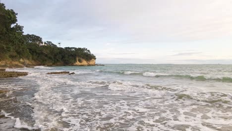 Slow-aerial-dolly-forward-over-waves-crashing-on-the-shore-of-New-Zealand