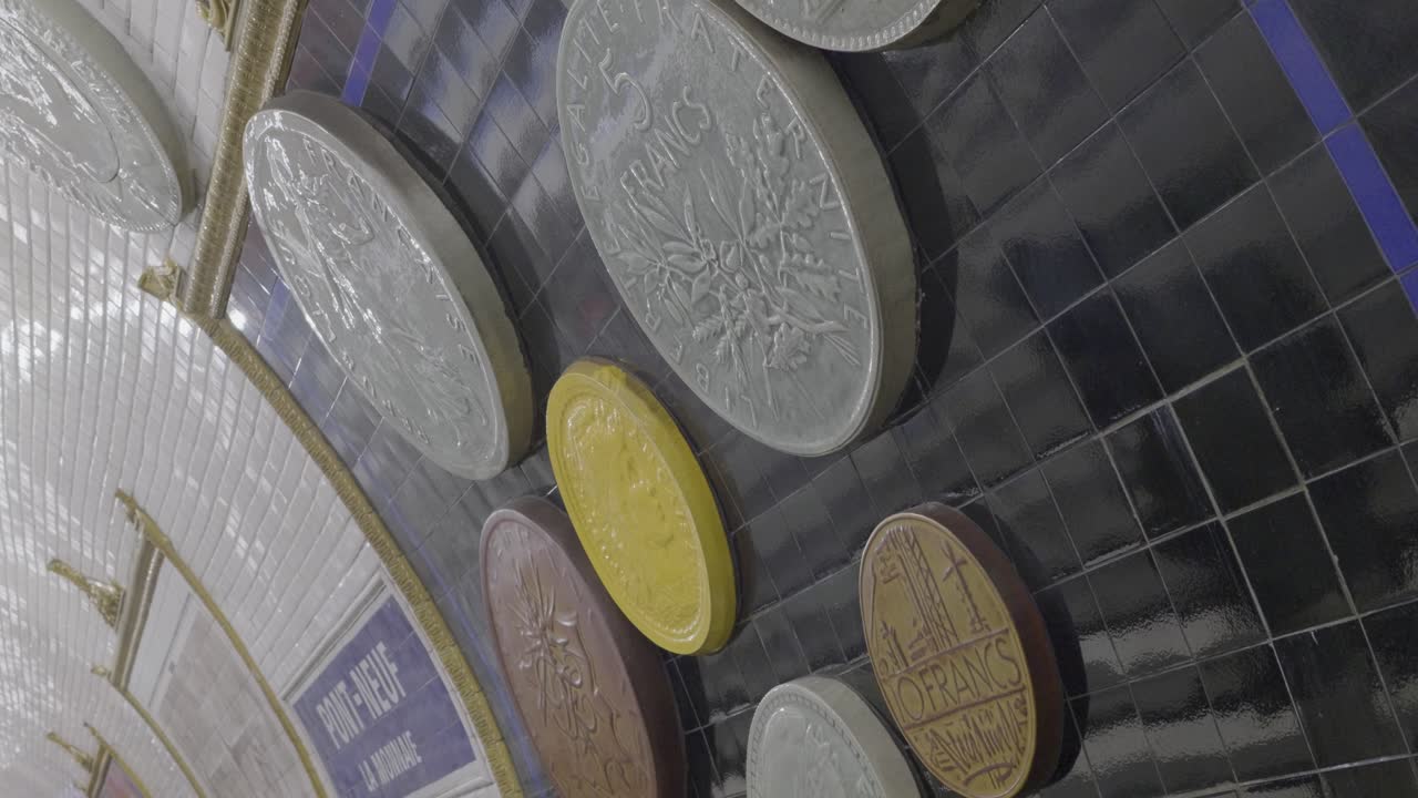 Mosaic of large coins displayed on a subway station wall, located in Paris Metro