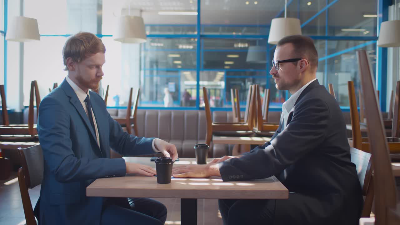 Restaurant owner and real estate agent sign contract and shake hands. Realtime