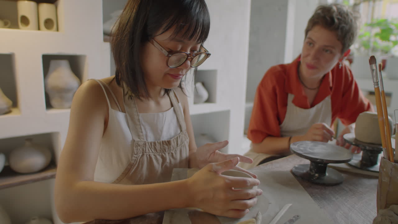Cheerful Girls Chatting during Ceramics Masterclass