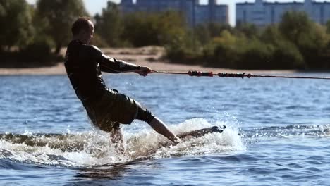 Wakesurfer-riding-board-on-waves-in-sunny-day.-Extreme-water-sport