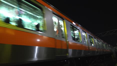 Tren-Nocturno-De-Japón-Pasando,-Cerca-De-La-Cámara,-Cámara-Lenta-De-4k