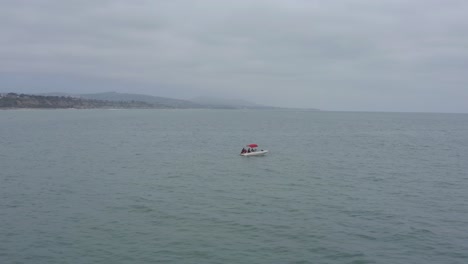 A-beautiful-aerial-drone-shot,-tracking-and-circulating-a-boat-in-the-ocean,-Dana-Point---Orange-County---California