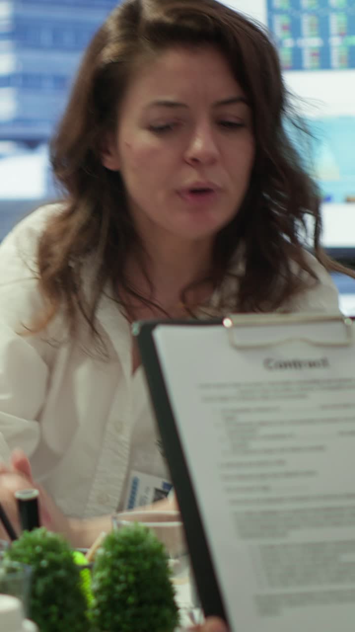 Video verticale: Esperto finanziario che mostra dati statistici su documenti in una sala conferenze