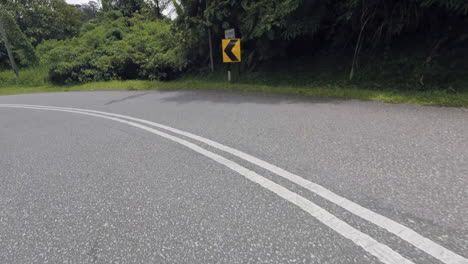 conduciendo por una carretera ventosa con un giro brusco a la izquierda en malasia