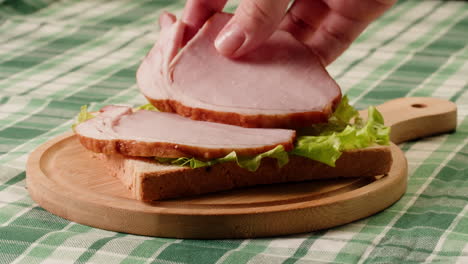 making a ham and lettuce sandwich