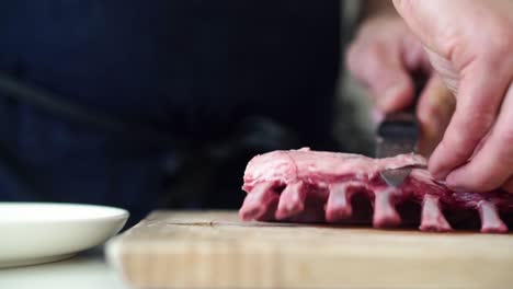 low angle view of chef trimming rack of lamb