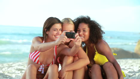 three friends pose for a photo at the beach