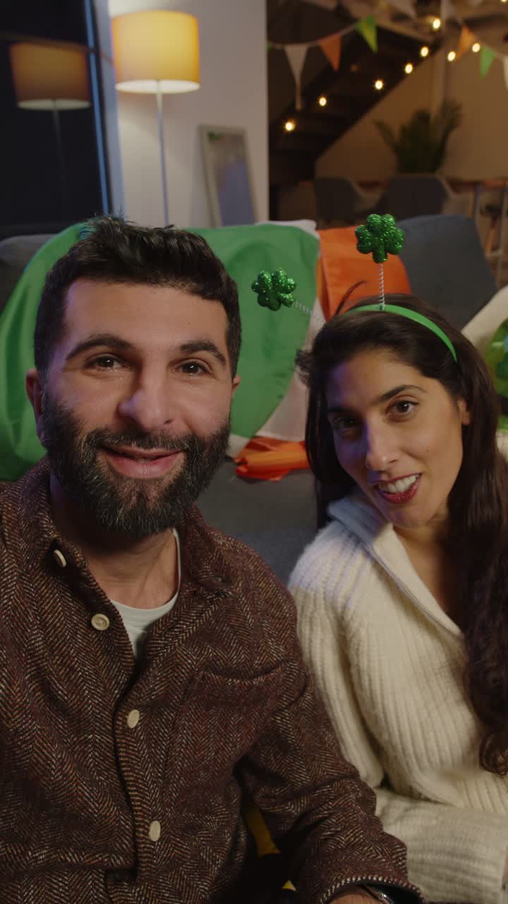 video pov verticale di amici che si vestono a casa per festeggiare la festa del giorno di san patrizio facendo una videochiamata sul telefono cellulare 1