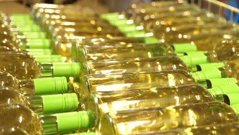 rows of white wine bottles with green caps ready for packaging