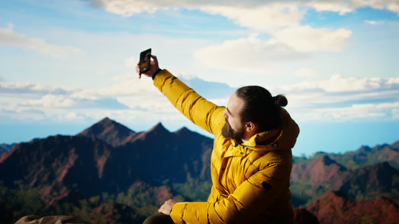 un joven excursionista encuentra inspiración para las imágenes en la cima de la montaña
