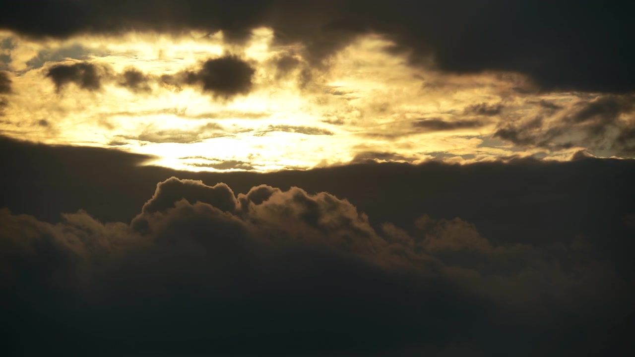 Golden Sunset Light Breaking Through Dark Storm Clouds