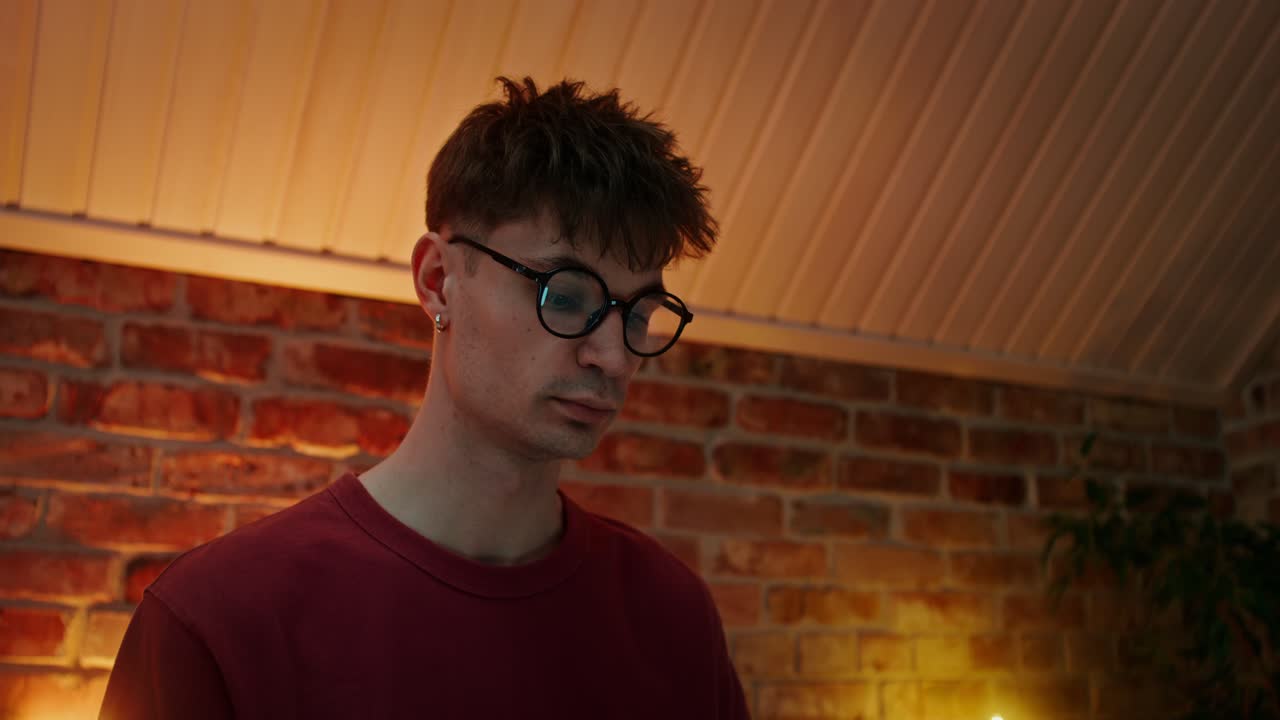 방에서 안경과 이어을 가진 젊은 남자