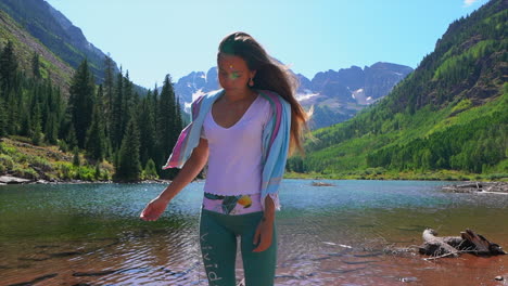Women-female-model-actress-standing-at-Maroon-Bells-stunning-lake-shoreline-Wilderness-Aspen-Snowmass-Rocky-Mountain-Colorado-summer-stunning-morning-Cinematic-gimbal-stabilized-follow
