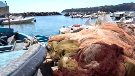 Barcos-De-Pesca-Amarrados-En-Un-Pequeño-Puerto-Cubierto-Con-Redes-De-Pesca,-Tiro-Panorámico