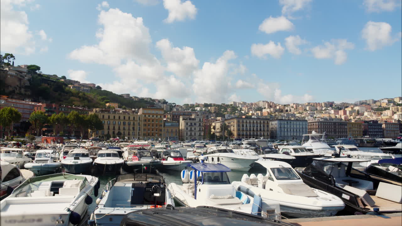 Barche e yacht ormeggiati in un porto turistico cittadino soleggiato.