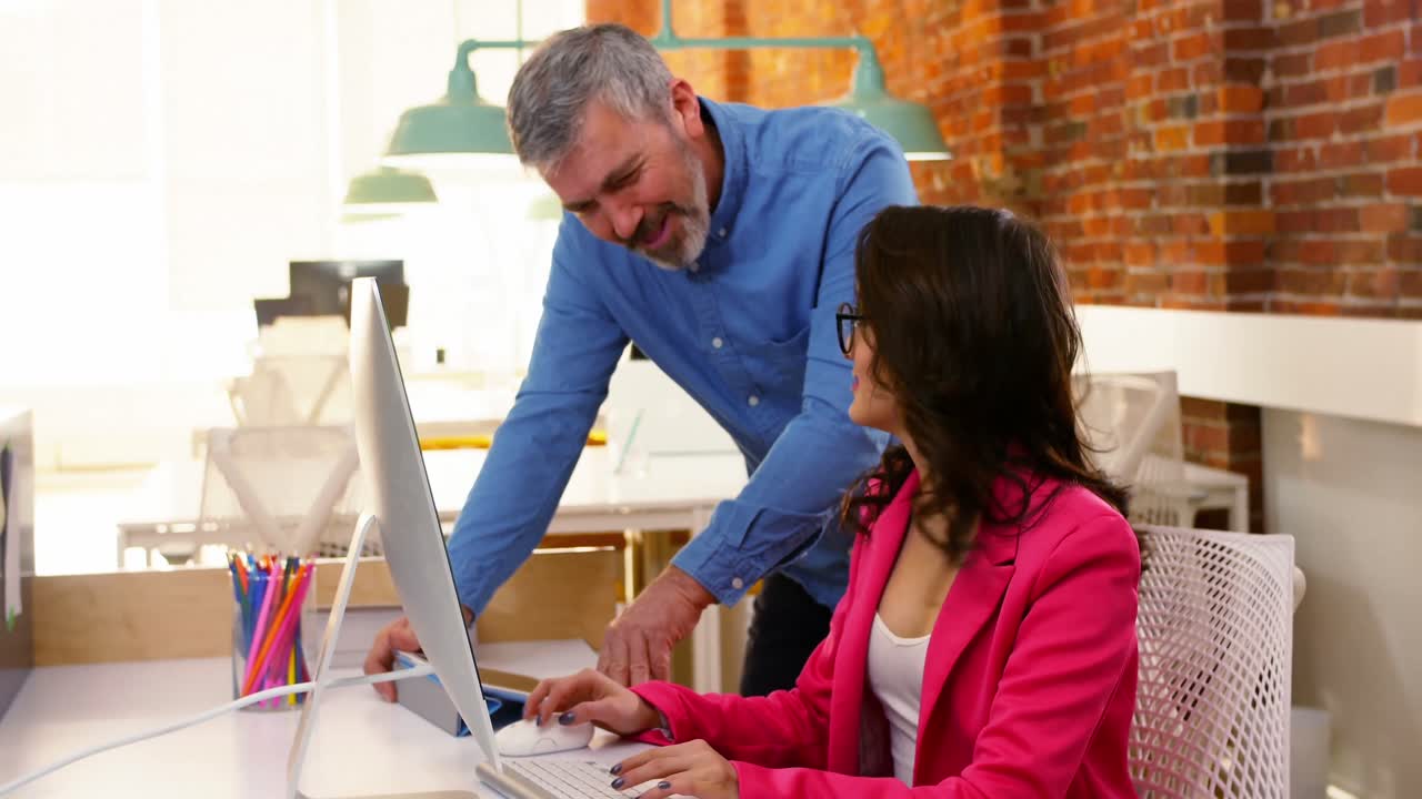 ejecutivos masculinos y femeninos discutiendo sobre la computadora en el escritorio