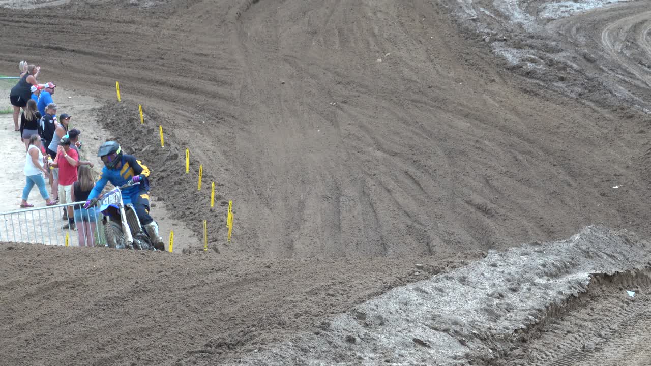 Pilotos de motocross competindo em uma pista de terra lamacenta