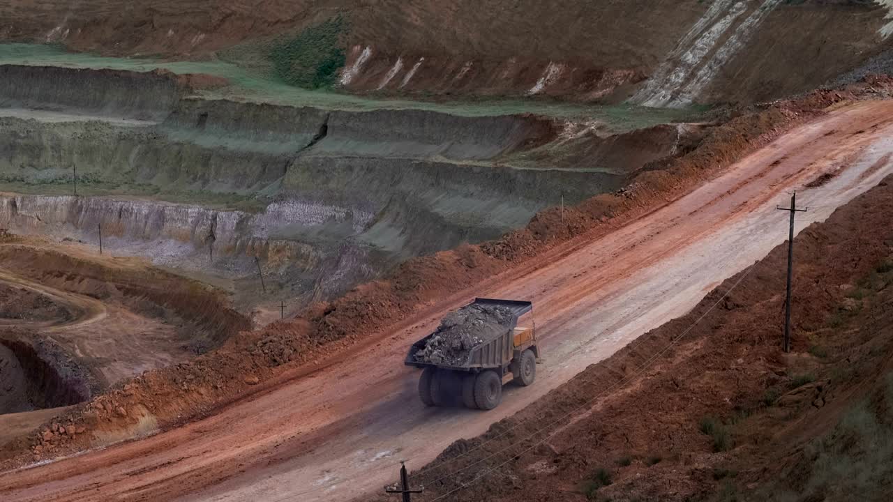 은 여름날에 오픈 캐스트 광산 광산에서 화물을 운반하는 무거운 광산 트럭의 중간.