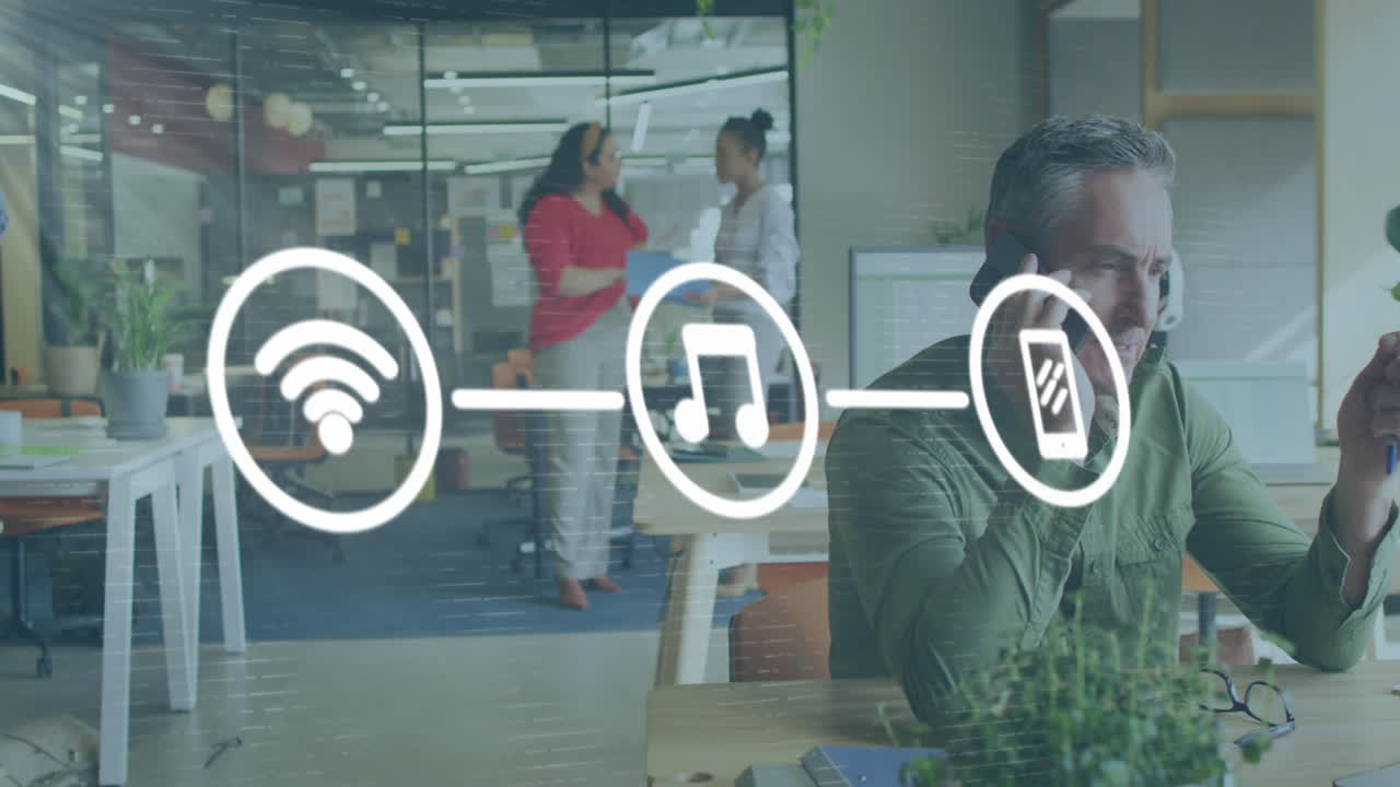 Animation of network of digital icons against caucasian man talking on a smartphone at office