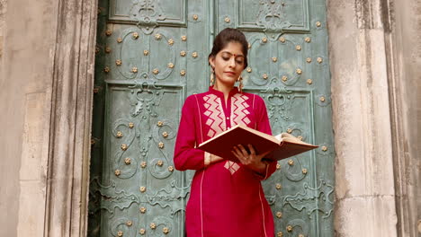 hermosa mujer india en rojo leyendo un libro