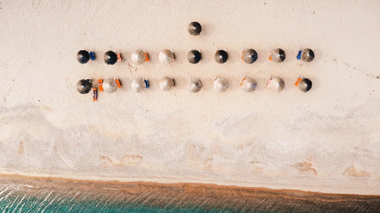 Beach with umbrellas and sunbeds. Foam. Top drone view