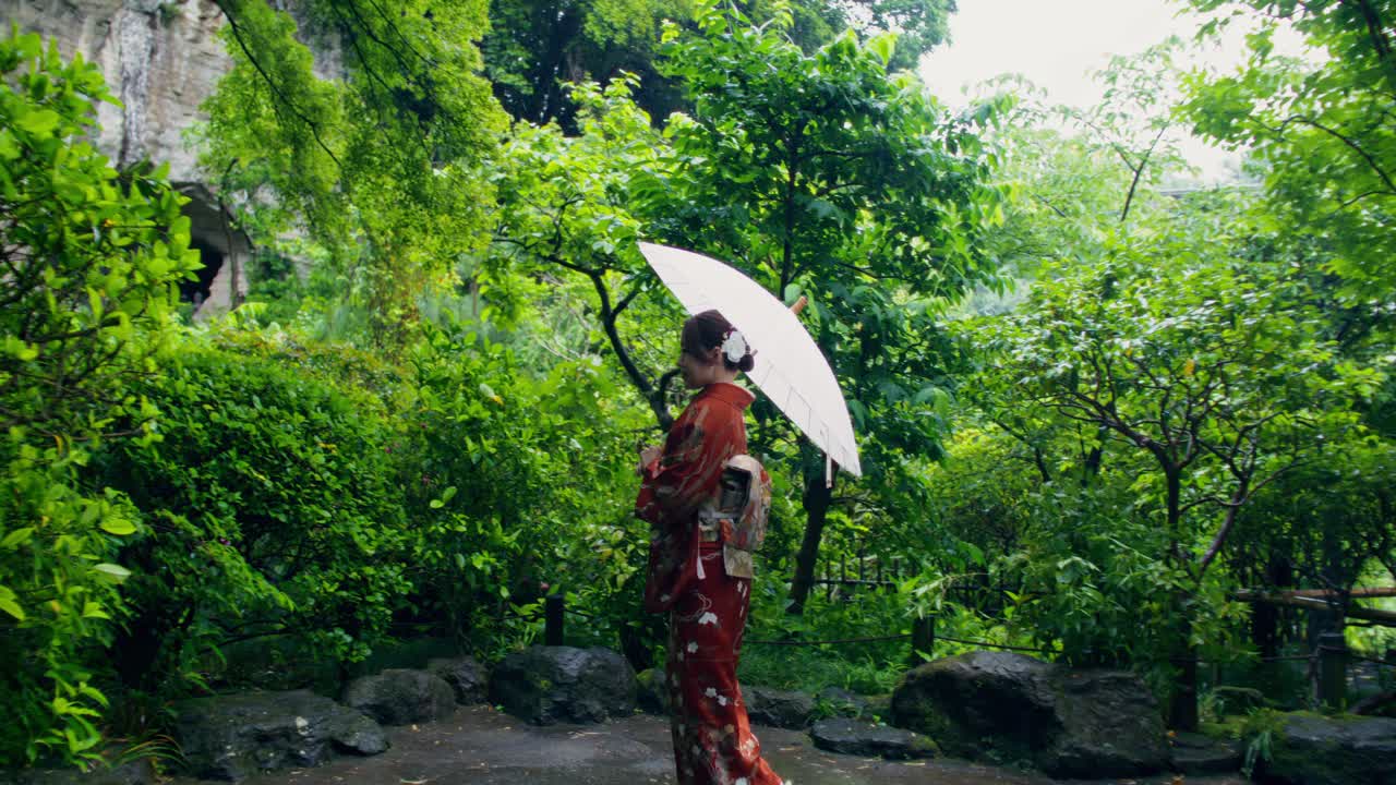 Woman in Kimono in a Japanese Garden during the Rain