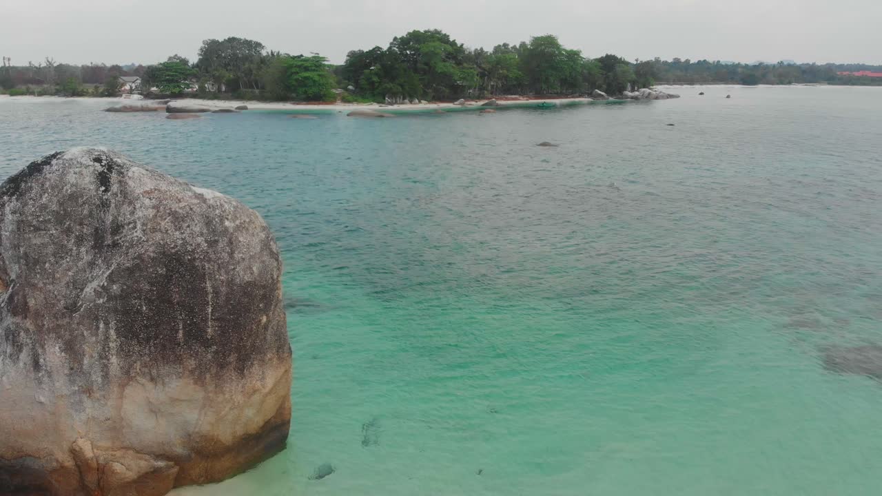 Vista aerea di una spiaggia tropicale incontaminata con palme e massi di granito a Belitung, Indonesia