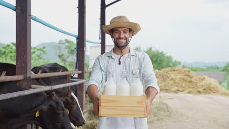 farmer holding a crate of milk bottles at a farm