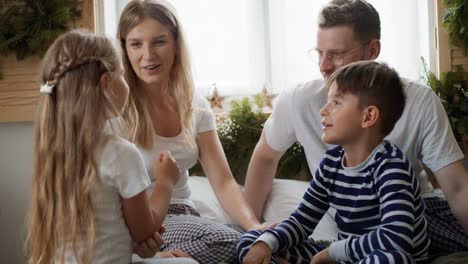 familia pasando la mañana de navidad juntos en la cama