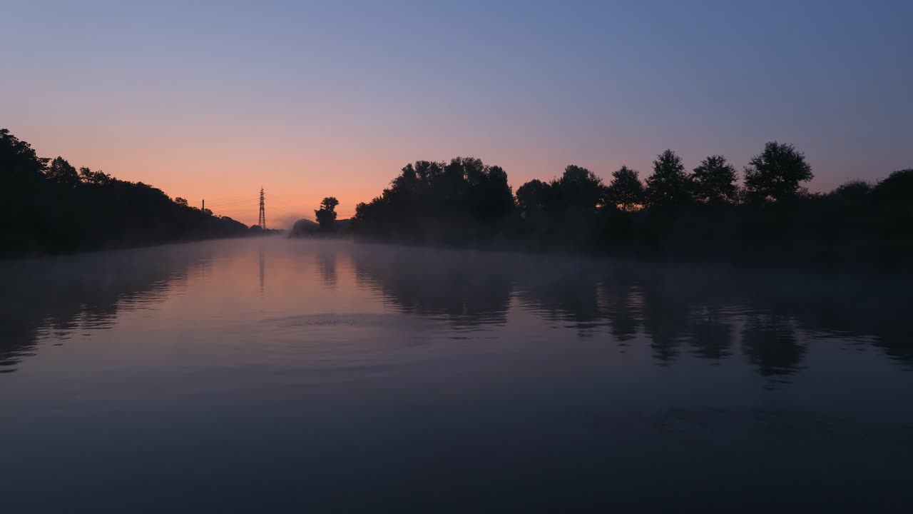 Sunrise over a misty river with an arch bridge
