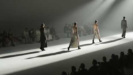 a captivating fashion show with models elegantly parading down the runway, illuminated by dramatic spotlights and surrounded by enthralled audience
