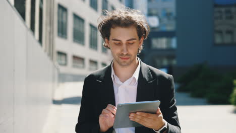 young businessman using a digital tablet outdoors