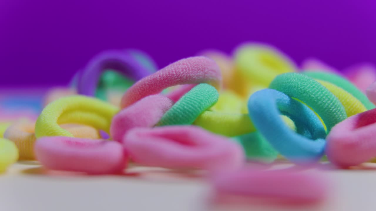 girando de cerca las bandas de goma textiles en el fondo violeta.