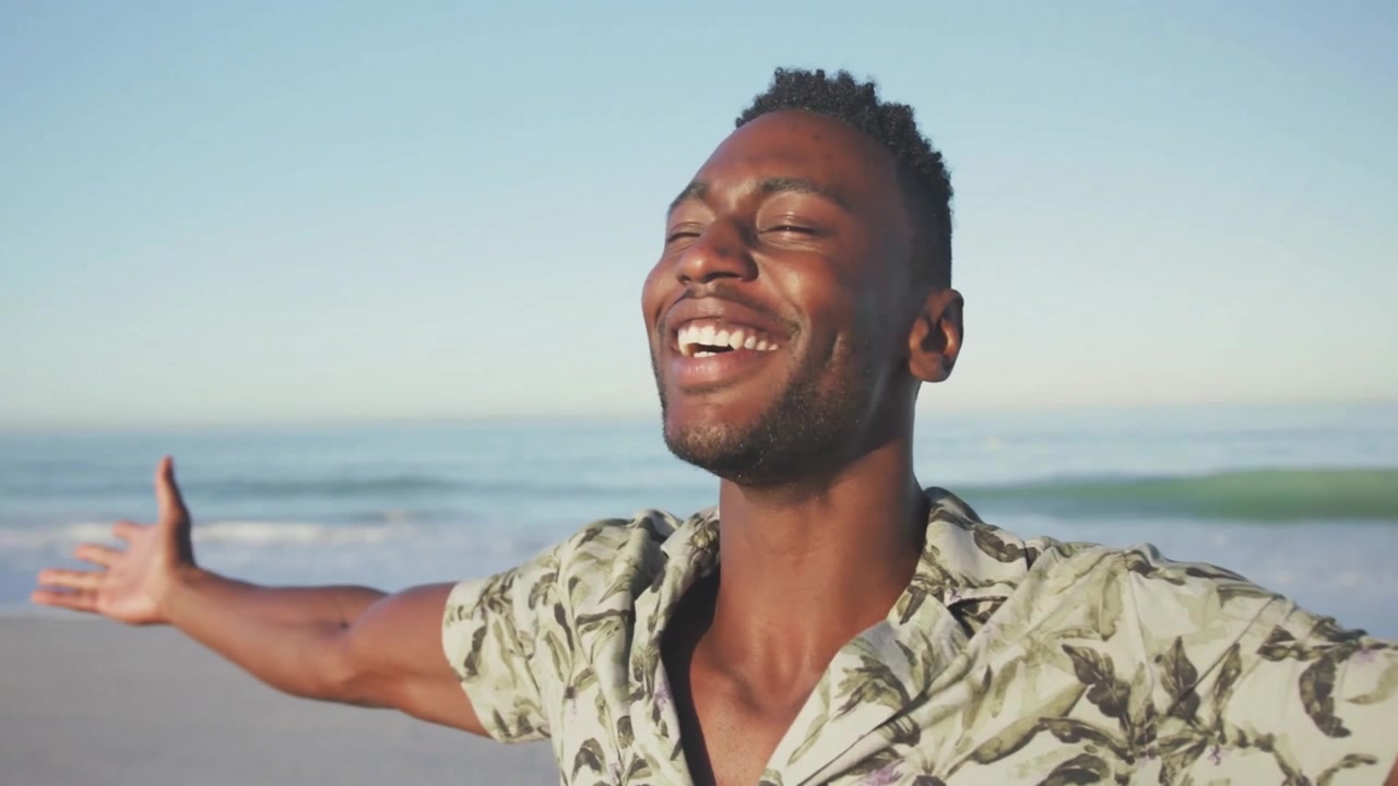 Marketinganzeige zeigt Mann, der am Strand die Arme ausbreitet, während eine US-Flaggen-Einblendung eingeblendet wird und Stolz hervorruft.