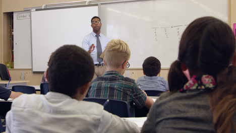 niños miran a la maestra en la clase de matemáticas, vista trasera, filmada en r3d