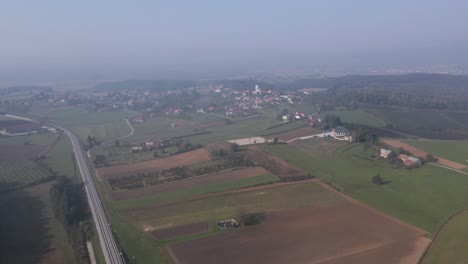 Vista-Aérea-A-Gran-Altitud-De-Tierras-De-Cultivo-Cerca-Del-Pueblo-De-Cresnjevec-En-El-Campo-De-Eslovenia-En-Una-Mañana-Nublada