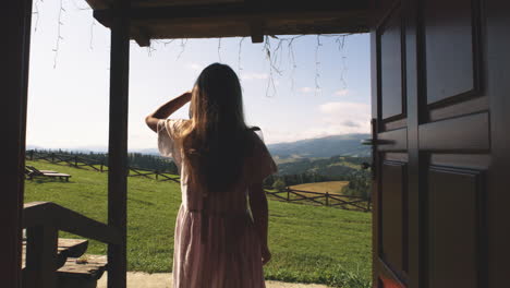 girl looking at mountain view from a cabin door