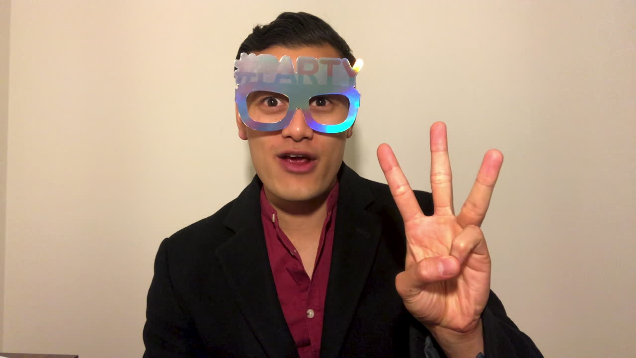 새해까지 화상 통화 카운트다운을 하고 파티 포퍼로 축하하는 청년