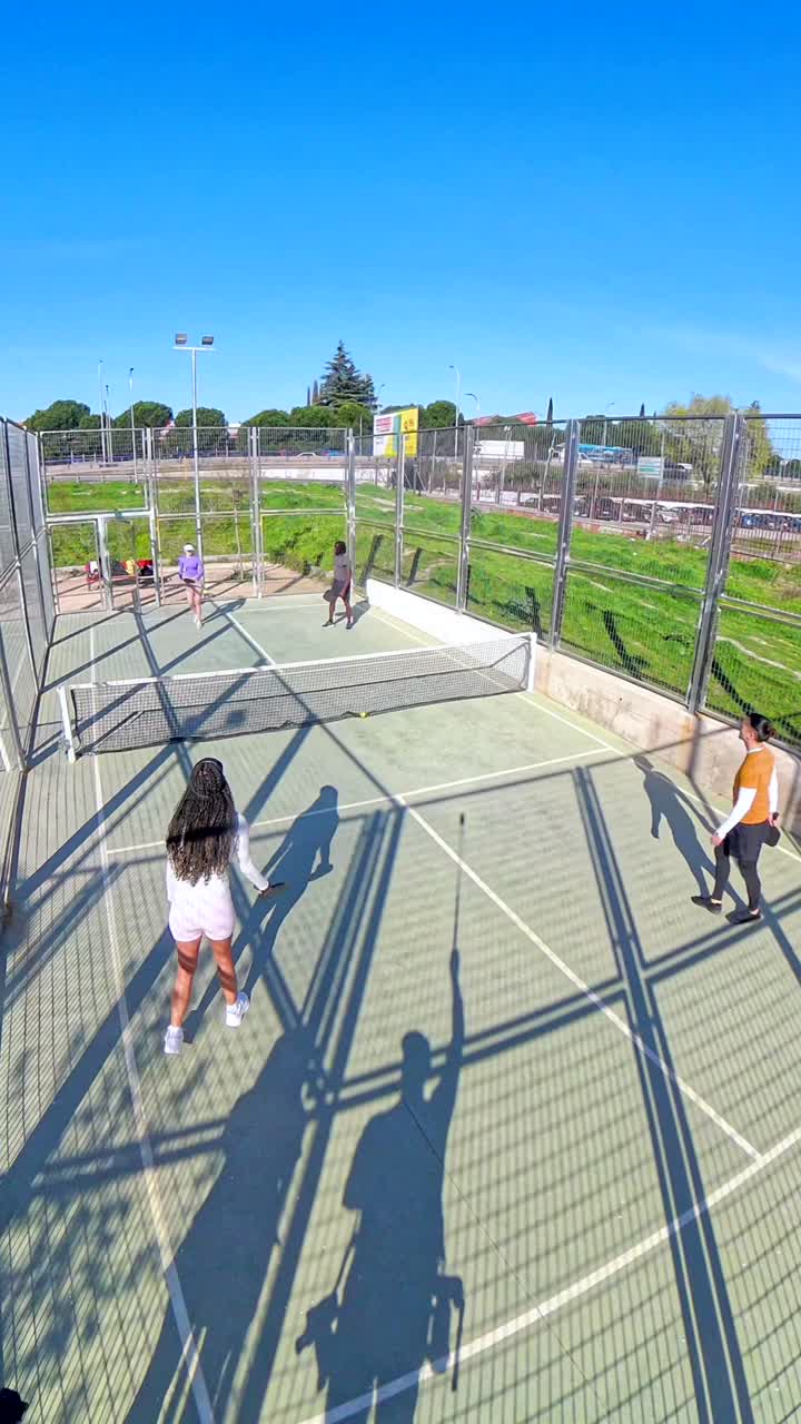 Grupo de mujeres jugando pádel en una cancha al aire libre en un día soleado
