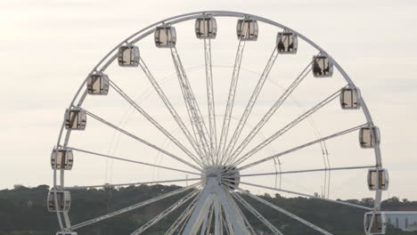 white spinning ferris wheel against a cloudy sky - medium shot