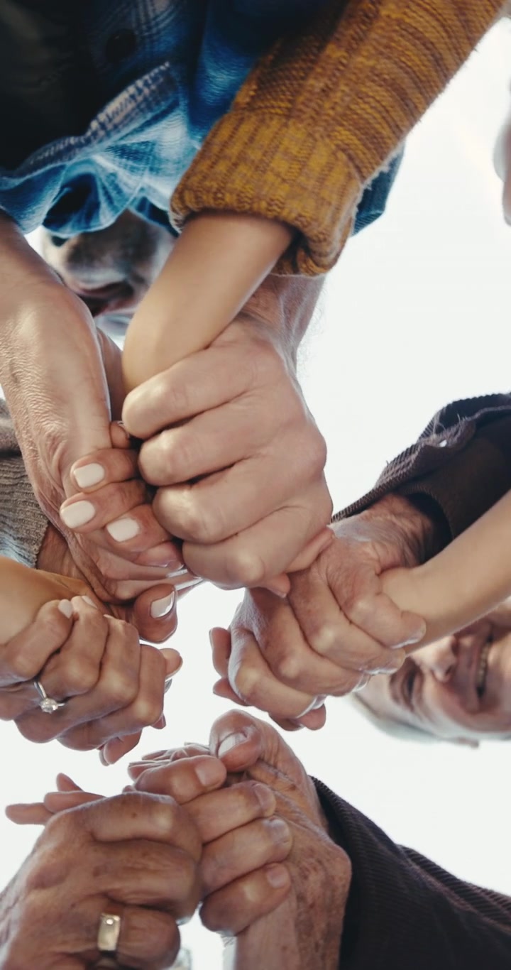 Un gruppo diverso di persone che si tengono per mano in cerchio