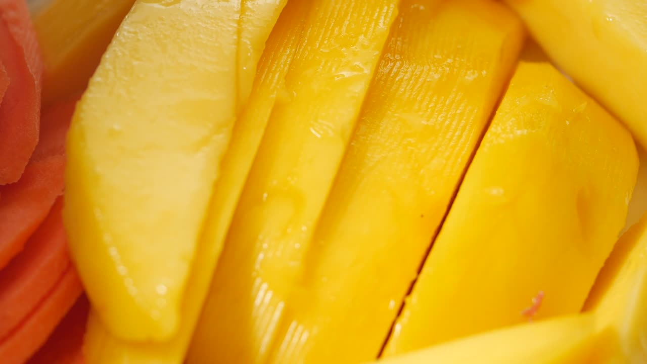 Nærbilde av lyse, gule mangoskiver på en tallerken