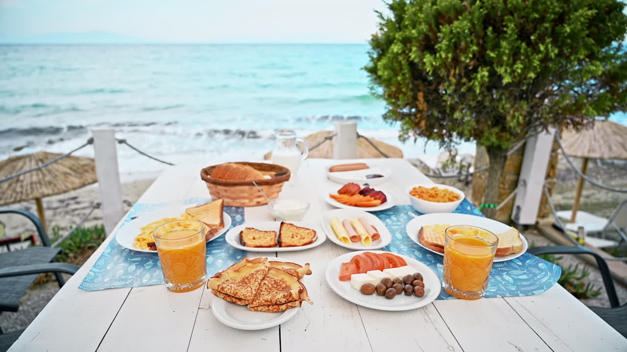 Table full of dishes with food, breakfast on the Aegean sea coast in Greece