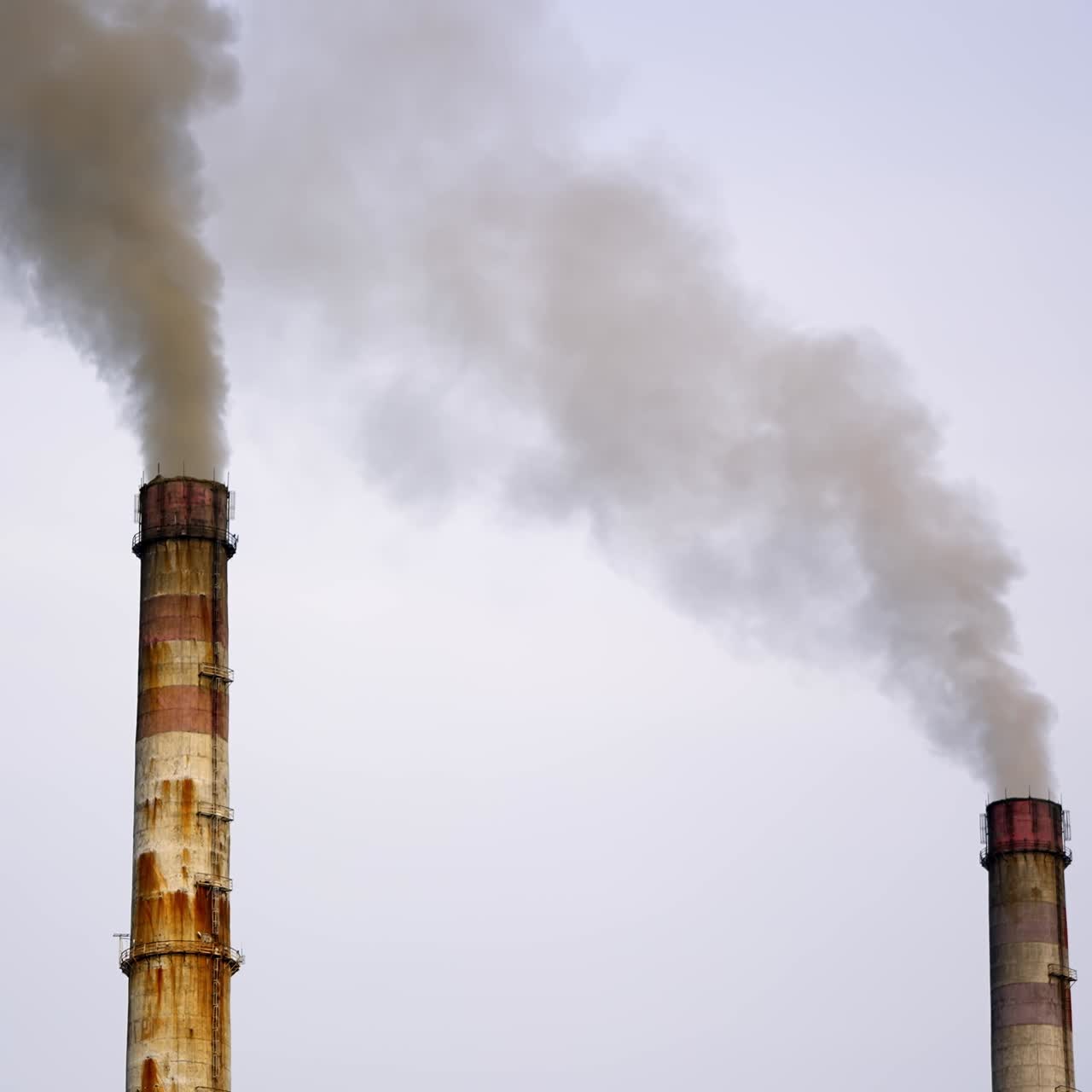 Old pipes with massive smoke in the sky. Dangerous emissions going up in the air. Pollution of the environment. Ecological problems