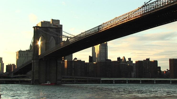 The Camera Shoots From Waterlevel To The Brooklyn Bridge Above And Buildings Beyond