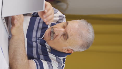 vertical video of home office worker old man has visual impairment problem.