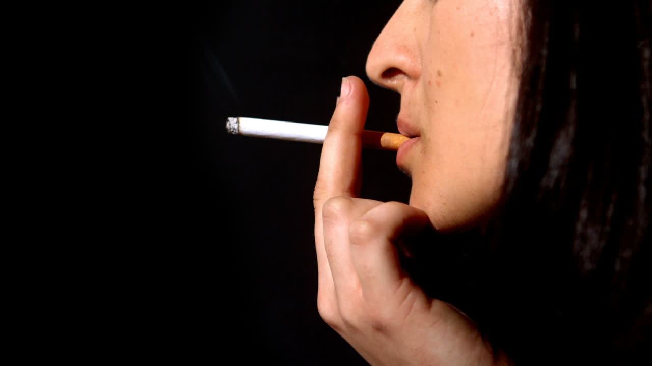 mujer fumando un cigarrillo a cámara lenta