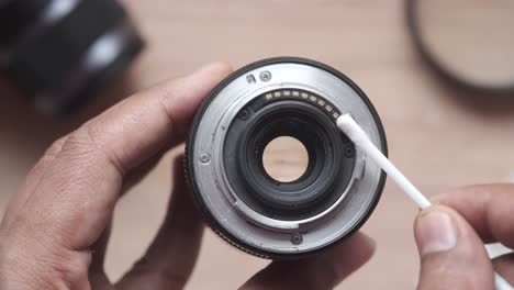 cleaning a camera lens with a cotton swab