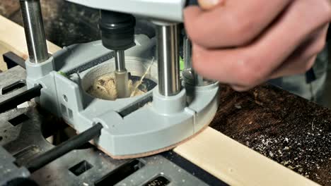 close-up of a carpenter's hand working with an manual electric cutter in a home workshop.